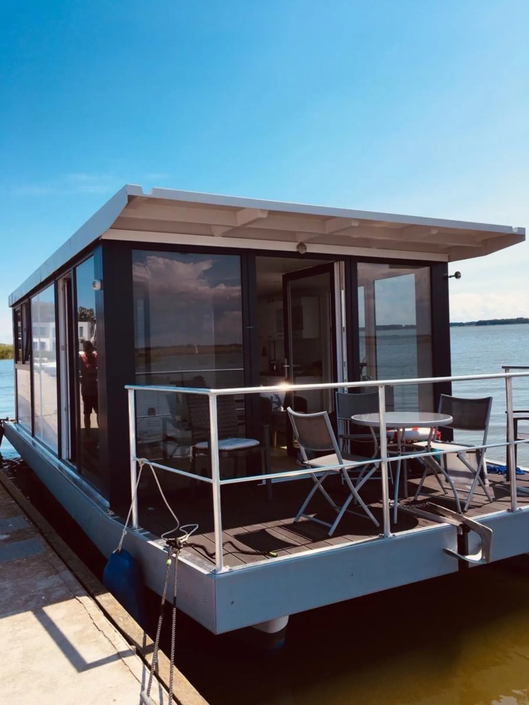 Fertige schwimmende Plattformlösung mit verglastem Wohnmodul und Terrasse am Steg