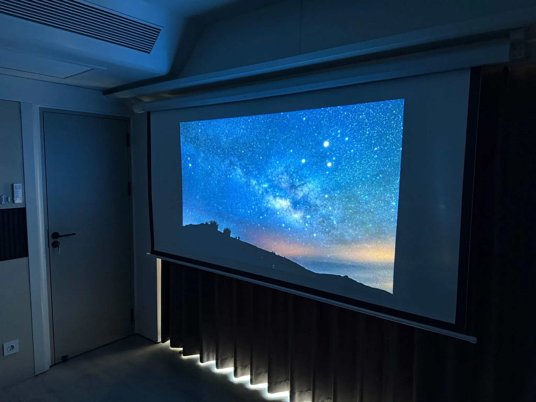 Sternenhimmel auf der ausgefahrenen Projektionsleinwand im abgedunkelten Wohnraum der MK I
