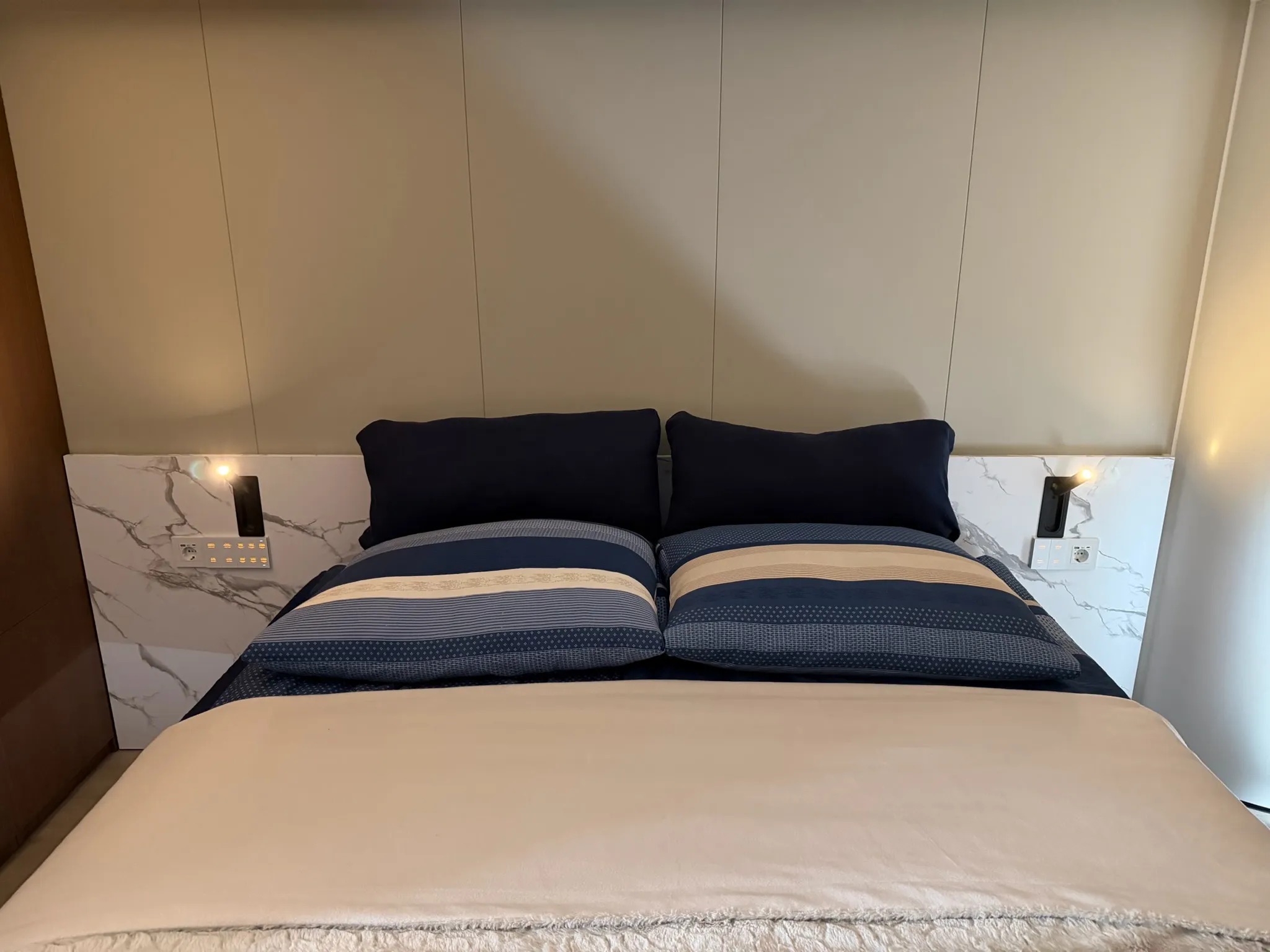 Schlafbereich der MK I mit Doppelbett und eingeschalteten Leselampen am Kopfteil