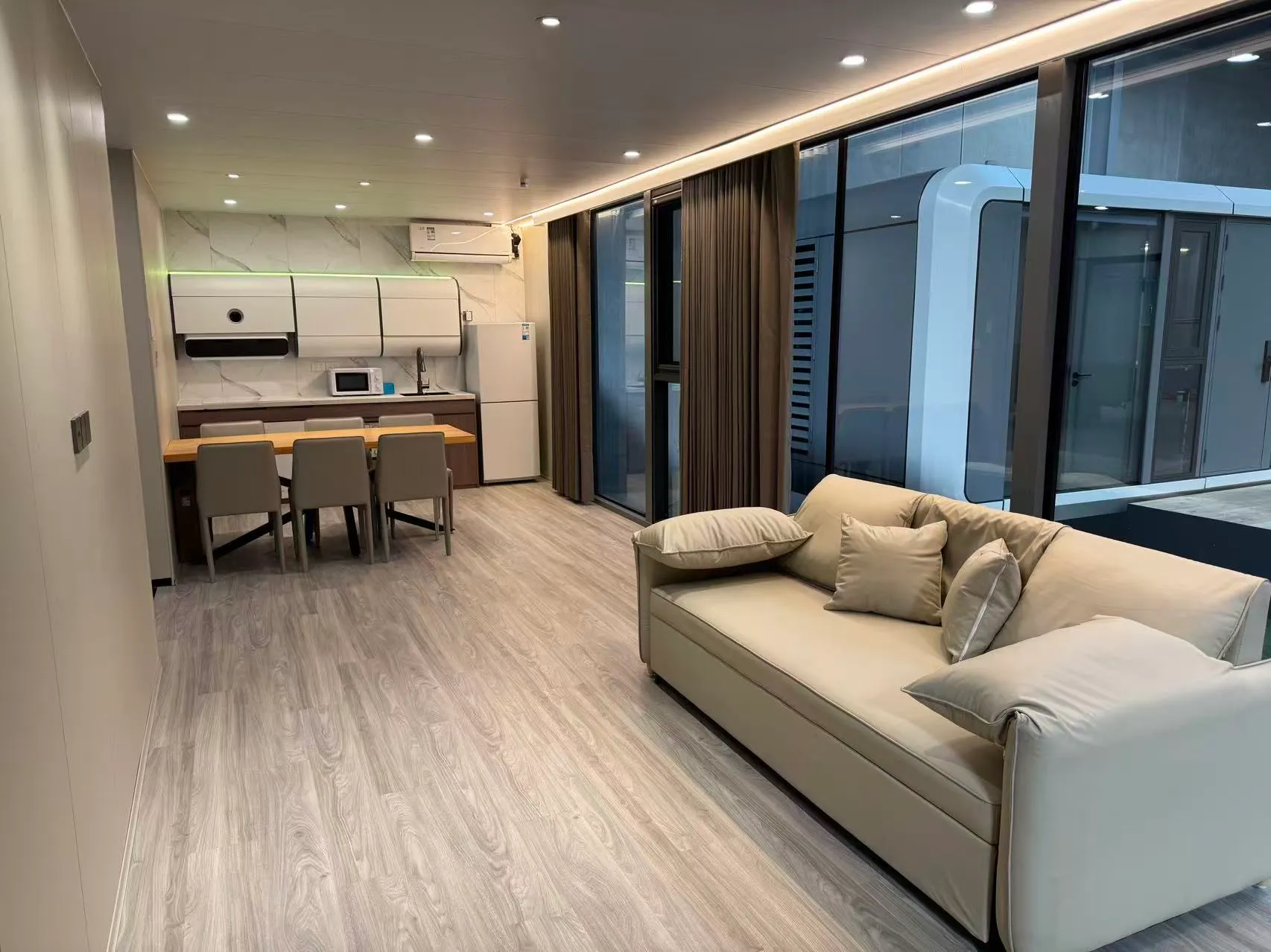 Wohnzimmer der MK II mit Küchenzeile, Esstisch und Sofa
